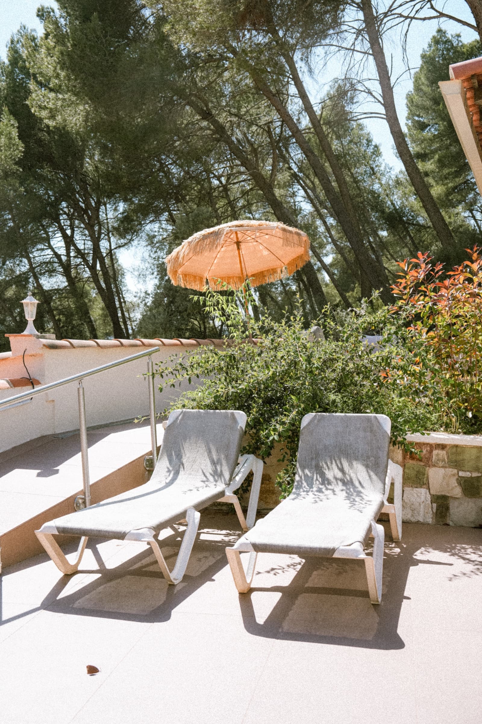 Terrasse haute avec transats et parasol sous la pinède
